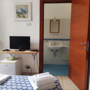 オートラントにあるMediterraneo Camereのベッドルーム1室(ベッド1台付)、バスルーム(シンク付)