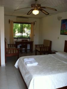 a bedroom with two beds and a table and chairs at Pedasi Sports Club in Pedasí Town