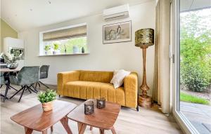 salon z żółtą kanapą i stołem w obiekcie Cozy Home In Oosterwolde With Sauna w mieście Oosterwolde