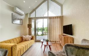 salon z żółtą kanapą i dużym oknem w obiekcie Cozy Home In Oosterwolde With Sauna w mieście Oosterwolde