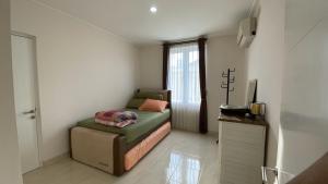 ein kleines Schlafzimmer mit einem Bett und einem Fenster in der Unterkunft Blessimore Springhill 4BR in Palembang