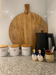 three rubber ducks are standing in front of a wooden barrel at Wanaka Deluxe Studio in Wanaka