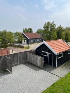 a black building with a red roof on a patio at Residence het Centrum in Oostkapelle