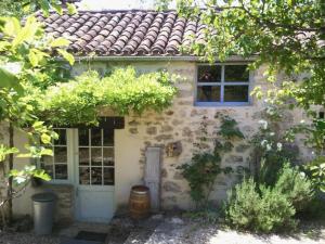 una antigua casa de piedra con una ventana y una puerta en La Framie basse, en Albas