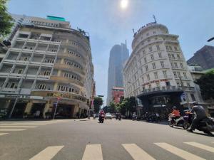 a group of people riding motorcycles down a city street at Tan Hoang Long Hotel in Ho Chi Minh City