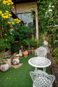 einen Tisch und Stühle in einem Garten mit Blumen in der Unterkunft Sabai Sabai@Sukhumvit Hotel in Bangkok
