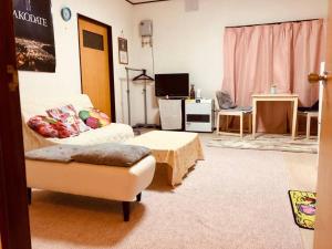 un salon avec un canapé et une table dans l'établissement Corpo Marika C, à Hakodate