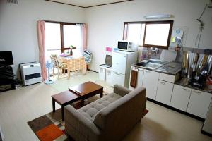 a living room with a couch and a kitchen at Corpo Marika C in Hakodate