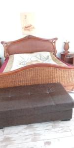 a large wooden bed with a wooden foot board at хотел Кристиан in Sozopol
