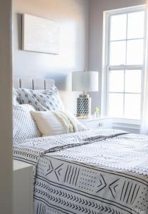 um quarto branco com uma cama com lençóis brancos e uma janela em West Edmon. Mall = Room em Edmonton