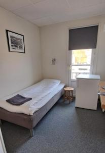 a small bedroom with a bed and a window at Kramfors Stadshotell AB in Kramfors