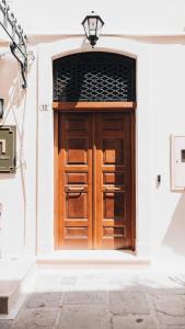 a large wooden door on a white building at MAZI - Pied à Terre in Rethymno