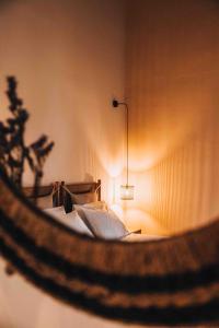 a bedroom with a bed with a light on the wall at MAZI - Pied à Terre in Rethymno Town