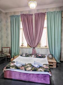 1 dormitorio con 1 cama grande frente a una ventana en Friendly Guest House, en Kutaisi