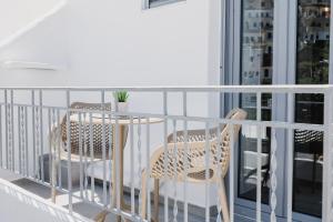 a balcony with two chairs and a table at VOLTO Suite in Kóronos