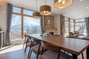 a dining room with a table and chairs with a mountain view at Akiyama in Kutchan
