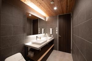 a bathroom with a sink and a mirror at Akiyama in Kutchan +28 photos