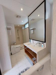 a bathroom with a sink and a mirror and a toilet at 盤古捷旅 - Panco Hotel in Taipei