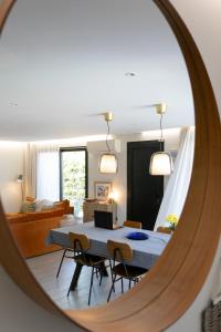 ein Spiegel mit einem Wohnzimmer mit einem Tisch und Stühlen in der Unterkunft Villas les Capucines in Sète