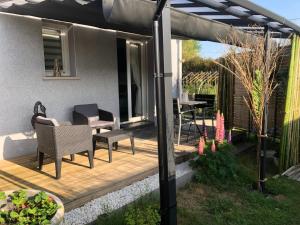 um pátio com uma mesa e cadeiras sob uma pérgola em Capbreton hossegor chambre climatisée espace privé em Bénesse-Maremne