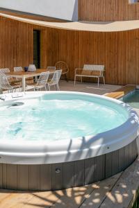 - un bain à remous sur une terrasse avec des chaises et une table dans l'établissement Villas les Capucines, à Sète