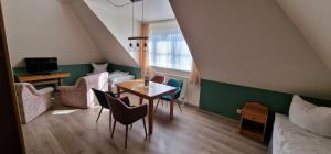 ein Zimmer mit Tisch und Stühlen und ein Schlafzimmer in der Unterkunft Hotel Mecklenburger Mühle Garni in Wismar