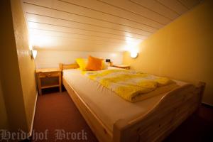 ein Schlafzimmer mit einem großen Bett mit gelber Bettwäsche in der Unterkunft Gästehaus Heidehof in Soltau