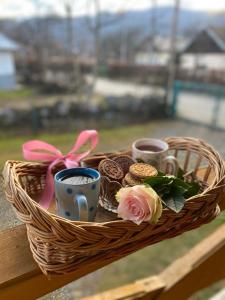 una cesta con tres tazas y flores en una mesa en Садиба "Сонячна" en Kosiv