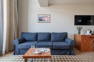 a living room with a blue couch and a coffee table at Royal Tulip Sand Zdrojowa Mezzanine Hotel Room by Renters in Kołobrzeg