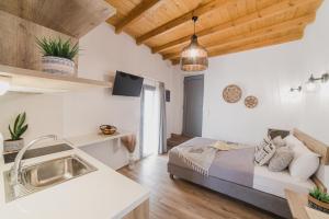 ein Schlafzimmer mit einem Bett und eine Küche mit einem Waschbecken in der Unterkunft VOLTO Suite in Kóronos