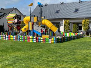 a playground with a slide in a yard at Amelia Domki in Sianozety