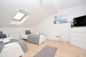 Dieses weiße Zimmer verfügt über 2 Betten und einen TV. in der Unterkunft ERH02-FW Apartment in Herzogenaurach in Herzogenaurach