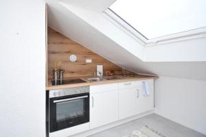 eine Küche mit weißen Schränken und einem Dachfenster in der Unterkunft ERH02-FW Apartment in Herzogenaurach in Herzogenaurach