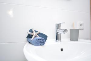 ein Waschbecken mit einem Handtuch und einem Seestern drauf in der Unterkunft ERH02-FW Apartment in Herzogenaurach in Herzogenaurach