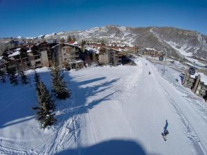 a person riding a snowboard down a snow covered slope at The Crestwood Snowmass Village in Snowmass Village