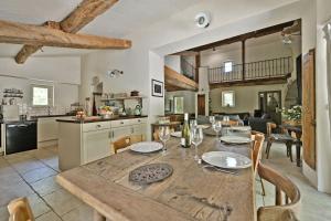 a kitchen and dining room with a wooden table at Mas Arguin - Charmante maison avec piscine in Barjac