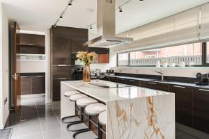 a kitchen with a large marble counter and stools at Luxury Water Tower I Roof Bar I Cinema in Cardiff