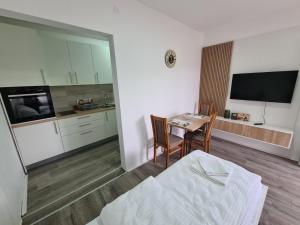 a room with a bed and a table and a kitchen at Vizura in Trebinje