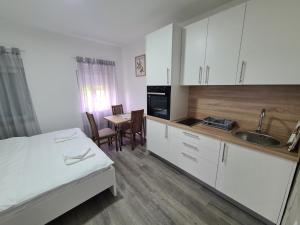 a bedroom with a bed and a kitchen with a table at Vizura in Trebinje