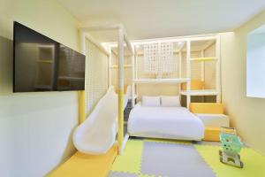 um pequeno quarto com uma cama e um escorrega em Doan Kids Hotel Yangsan em Yangsan