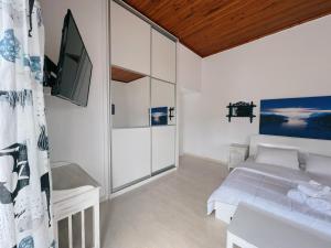 a white room with a bed and a tv at Villa Ancora Spetses in Spetses