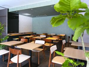 a classroom with wooden tables and chairs and plants at Villa Fontaine Tokyo Kudanshita in Tokyo