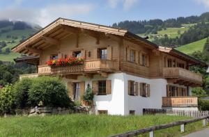 a wooden house with a balcony on a hill at Appartement Riedl Martin in Brixen im Thale