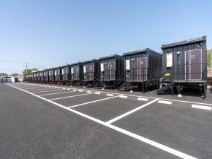 a row of train cars parked in a parking lot at HOTEL R9 The Yard Midori in Midori
