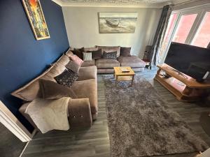 ein Wohnzimmer mit einem Sofa und einem TV in der Unterkunft Charming house welcome in Cardiff