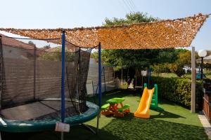 a backyard with a swing set and a playground at Tereza Apartments in Acharavi
