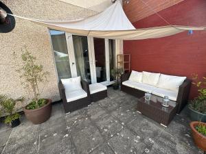 a patio with a couch and chairs and a tent at Charming house welcome in Cardiff