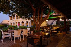 un patio con tavoli, sedie e un albero di Tereza Apartments ad Acharavi