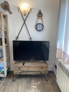 TV de pantalla plana sobre una mesa de madera en DUPLEX ALPINO, en Rialp