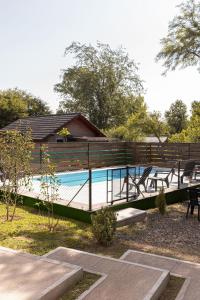 una piscina con una valla de madera y una casa en Laurentino Loft & Home, en Villa General Belgrano
